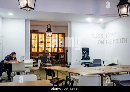 One male worker using laptop in an empty co-working space Stock Photo