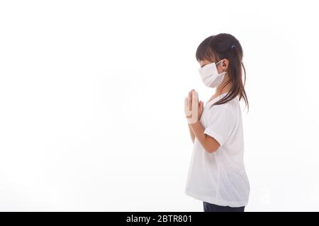 Asian girl wearing mask for protect pm2.5 and coronavirus Covid-19.Stay at home praying to GOD.Online church worship in sunday.Little asian girl hand Stock Photo