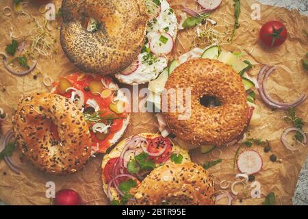 Tasty colorful various bagels with healthy ingredients served on brown baking paper Stock Photo