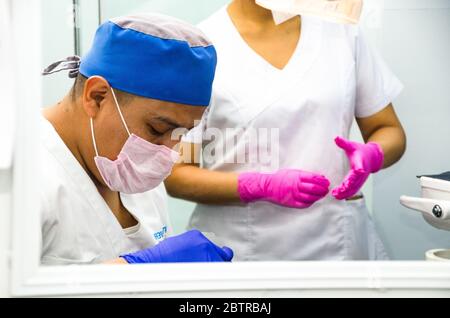 Portrait of two surgeons at work, operating in uniform, looking at the camera Stock Photo