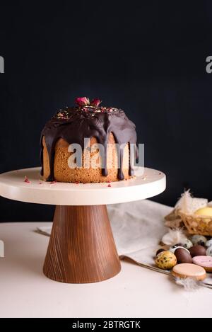 Easter cake on a beautiful stand with chocolate glaze Confectioner decorates the cake with glaze. Stock Photo