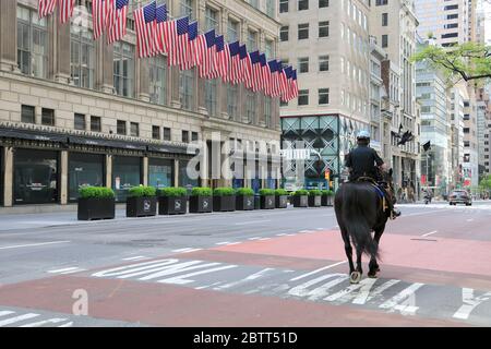 Policeman on horse patrolling empty 5th Avenue during Coronavirus Lockdown, New York City, USA May 2020 Stock Photo