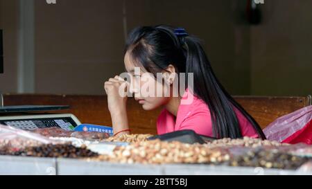 Beijing / China - June 21, 2015: Pretty vendor girl selling street snack food in Beijing Stock Photo