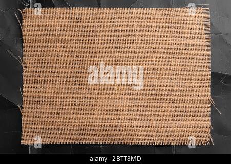 Sackcloth on black crumpled paper with wrinkles and folds. Abstract textural background. For design, menus and titles. Stock Photo