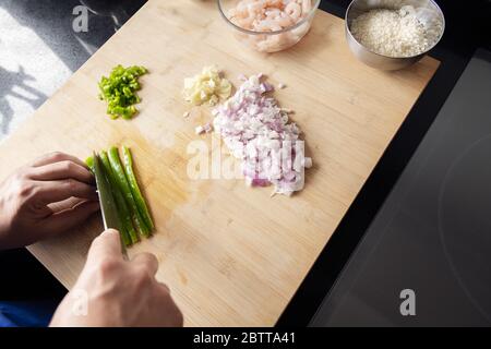 top view of hands cutting vegetables on the cutting board in the kitchen, concept of healthy eating Stock Photo