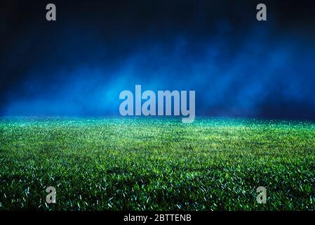 Close up of maintained lawn at football stadium. Night low view with abstract light effects. Iluminated mist. Stock Photo