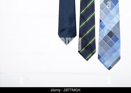 Men's ties on a white wooden background. Place for text Stock Photo