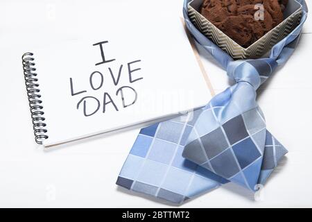 Notepad with text i love dad and a box with cookies. Daddy's Day Holiday Concept Stock Photo