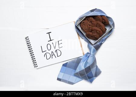 Notepad with text i love dad and a box with cookies. Daddy's Day Holiday Concept Stock Photo