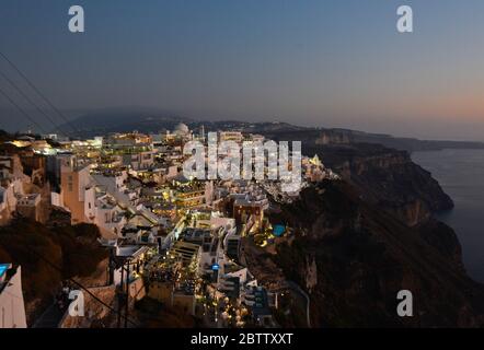 Sunset over the sea and twilight at the white-washed houses in Fira, Stantorini. Greece Stock Photo