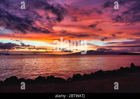 Amazing fiery sunset from the shores of Maui out to the nearby islands of Lanai and Molokai. Stock Photo