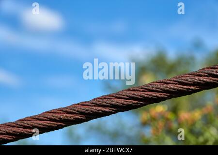 Rusty wire rope protects gardens in which fruit trees stand that bear ripe fruit, Germany. Stock Photo