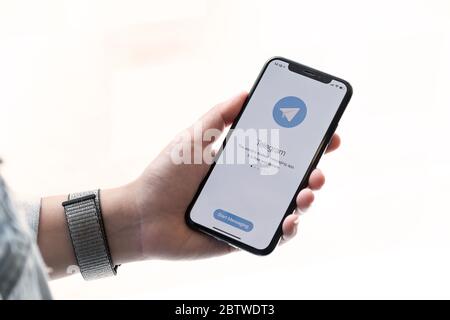 CHIANG MAI, THAILAND, OCT 27, 2019 : Woman hand holding iPhone X with social networking service Telegram on the screen. Stock Photo