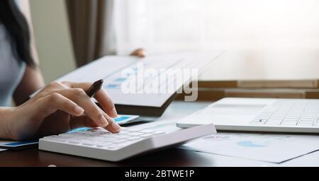 Close up accountant banker or bookkeeper making calculations with calculator. Savings, finances and economy concept Stock Photo