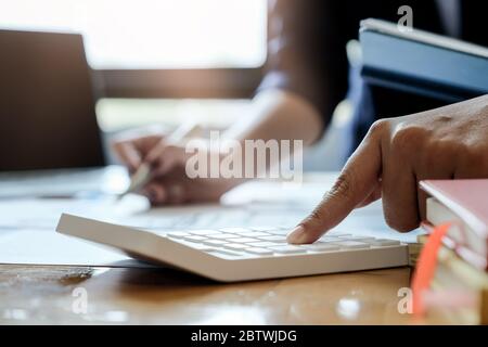 Close up view of bookkeeper or financial inspector using calculator for calculating or checking balance. Stock Photo
