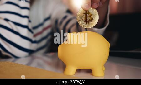 Business woman put bitcoin to piggy bank, bit coin BTC the new electronic money, Stock Photo
