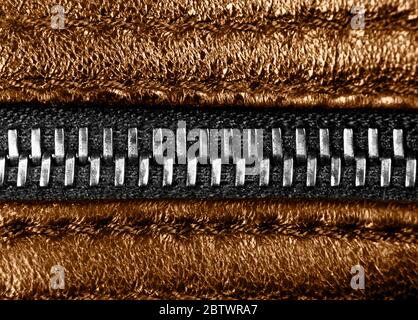 Macro shot of zipper onbrown leather texture background with stitching. Horizontal background from a close-up of orange leather material Stock Photo