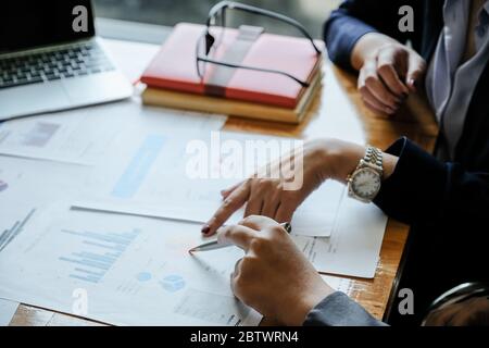 Close up of business people analyzing data from financial documents while working in the office Stock Photo