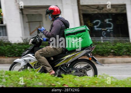 Kuala Lumpur, Malaysia. 27th May, 2020. A grab food rider seen with his phone while on his motorcycle during the movement control order at Kuala Lumpur. Malaysia had confirmed 15 new positive cases of Coronavirus on Wednesday and it is the lowest cases since the pandemic had started. Total of the pandemic cases are now up to 7619 and the total for recovered cases were 6083. Kuala Lumpur still have the most highly cases with the total 1987 cases. Credit: SOPA Images Limited/Alamy Live News Stock Photo