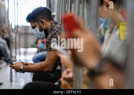 Kuala Lumpur, Malaysia. 27th May, 2020. Train passengers seen with their phone during the movement control order at Kuala Lumpur. Malaysia had confirmed 15 new positive cases of Coronavirus on Wednesday and it is the lowest cases since the pandemic had started. Total of the pandemic cases are now up to 7619 and the total for recovered cases were 6083. Kuala Lumpur still have the most highly cases with the total 1987 cases. Credit: SOPA Images Limited/Alamy Live News Stock Photo