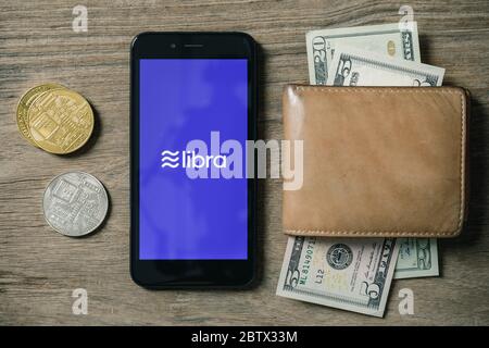 Chiangmai, Thailand - June 27th, 2019: Smartphone with Libra logo on the screen and Cryptocurrency digital golden coins, Facebook announces Libra cryp Stock Photo