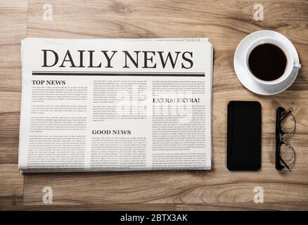 Newspaper with the headline News and glasses and coffee cup on wooden table, Daily Newspaper mock-up concept Stock Photo
