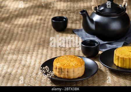 Moon cake with cup of hot tea on the the wooden table background with copyspace for your text, Asian traditional festival concept Stock Photo