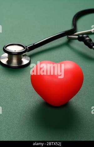 Composition of stethoscope and red heart on white background with copy ...