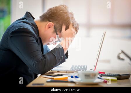 Sad businessman stressed and worried sitting in office. Stress and worry concept. Vintage tone Stock Photo