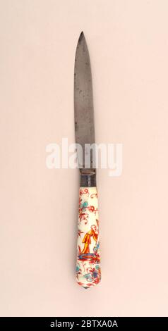 Knife with Chinese Figure on Porcelain Handle. Research in ProgressLeaf-shaped blade with staright sides. Plain bolster. Silver ferrule with horizontal bands. Tapering white porcelain handle with kakiemon design in green, blue and yellow (underglaze) and red-brown overglaze. End of handle rounded with silver button cap. Stock Photo