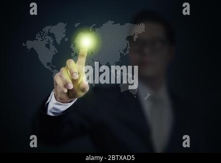 Business Man pushing a world on touch screen interface. Business, technology, internet and networking concept. Stock Photo