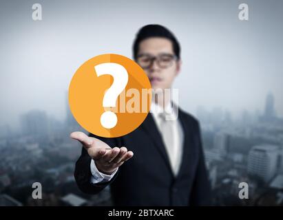 Businessman hand holding question mark, new business in the city collection, studio shot Stock Photo