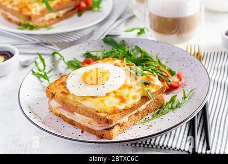Breakfast.  Hot sandwich. Croque madame sandwich and a cup of latte macchiato coffee on the table. French cuisine. Copy space Stock Photo