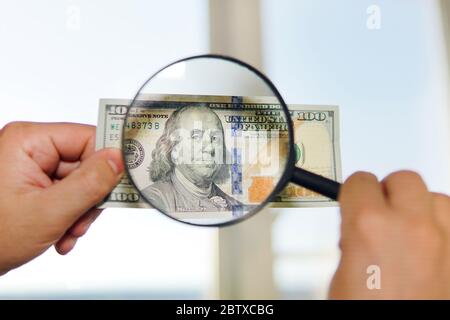 two dollar bill and magnifying glass isolated on white Stock Photo