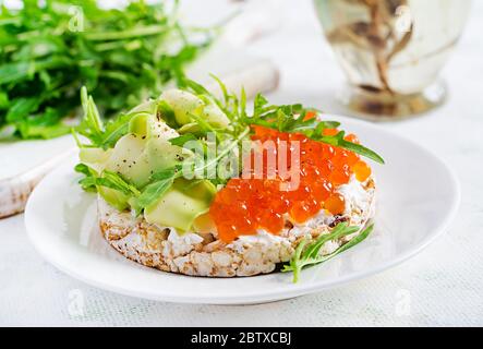 Crispbread sandwiches with red caviar, avocado and cream cheese  in plate. Stock Photo