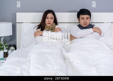 sick couple feeling cold and suffering from virus disease and fever on bed at home Stock Photo