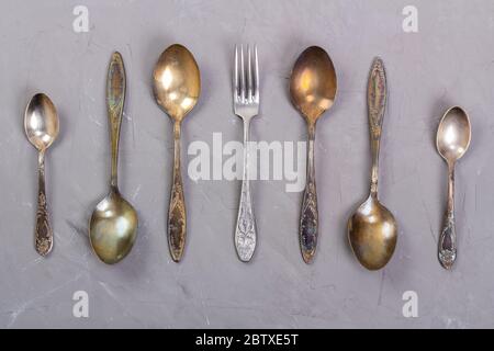 Antique cutlery laid out on a gray background Stock Photo
