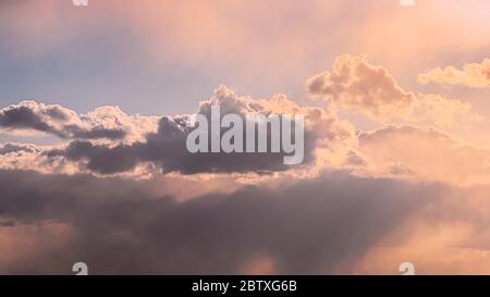 Sun Rays Shining Through Cloudy Sky With Fluffy Clouds. Sunset Sky During Rain. Stock Photo