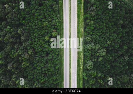 Aerial View Of Highway Road Through Green Forest Landscape In Summer. Top View Flat View Of Highway Motorway Freeway From High Attitude. Trip And Trav Stock Photo