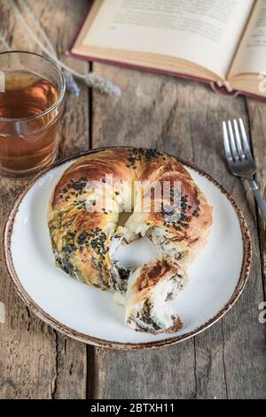 book, savory pastry and tea on wooden table for breakfast Stock Photo