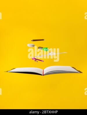 Levitating school supplies for math - notebook, pen, ruler, pencil, divider and eraser on yellow background. Concept of education and creativity Stock Photo