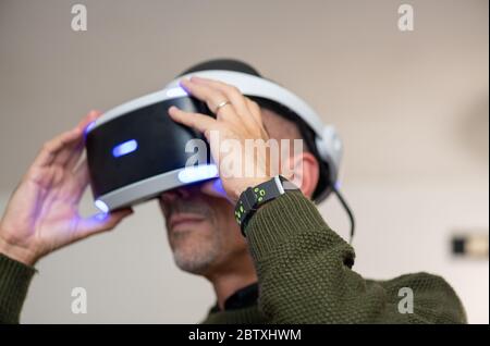 Man having fun with virtual reality, using VR glasses at home. Stock Photo
