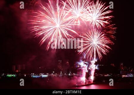 Fantastic red fireworks splashing in the night sky over the harbor Stock Photo