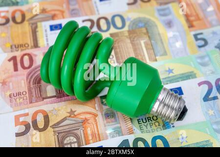 Green energy-saving lamp on euro banknotes, Germany Stock Photo