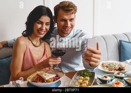 Happy young couple making selfie in restaurant Stock Photo