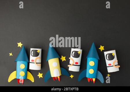 School kindergarten crafts, paper spaceship, shuttle, astronaut on black background with copy space for text. Party, start up launch concept, diy, cre Stock Photo