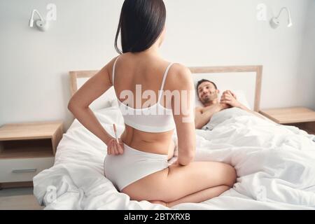 Happy spouse smiling at his wife in bed Stock Photo