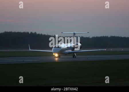 Private jet plane taxiing on the runway in the dark, ready to take off. Business aviation. Stock Photo