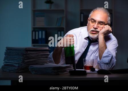 Old employee working late in the office Stock Photo