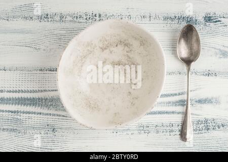 an empty and clean ceramic bowl and spoon on a table Stock Photo
